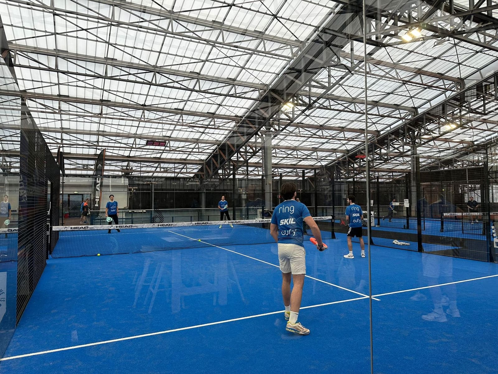 Speler slaat de bal op een indoor padelbaan